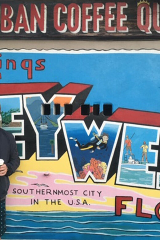 Peter Hinman standing in front of KeyWest postcard graphic and Cuban Coffee sign