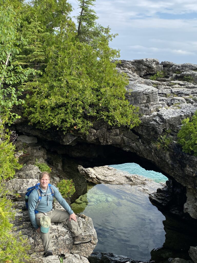 Man sitting on rocks near grotto by the lake