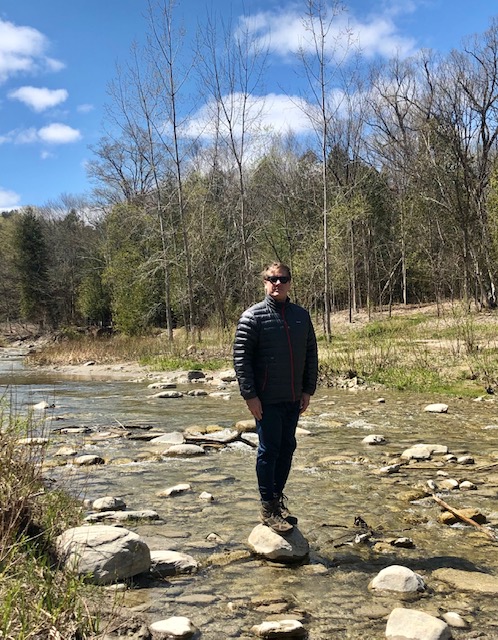 Man standing on a rock in the middle of a river, The Rouge River