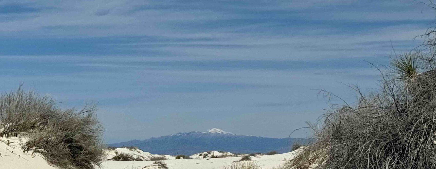 white sands and blue sky with mountain i